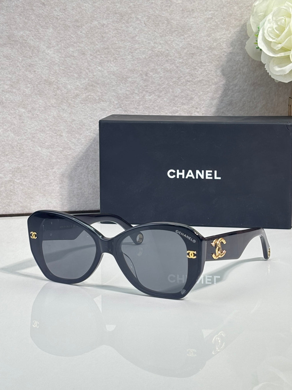 Navy Chanel sunglasses with gold-tone logos on temples and dark tinted lenses