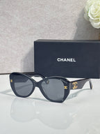 Navy Chanel sunglasses with gold-tone logos on temples and dark tinted lenses