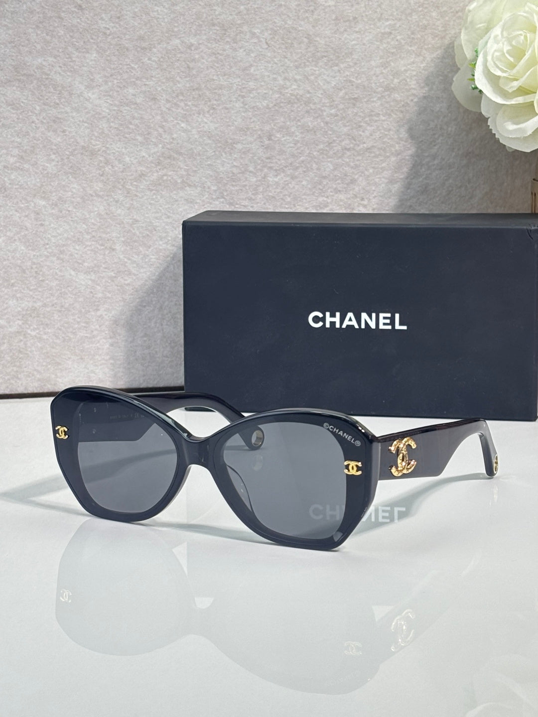 Navy Chanel sunglasses with gold-tone logos on temples and dark tinted lenses