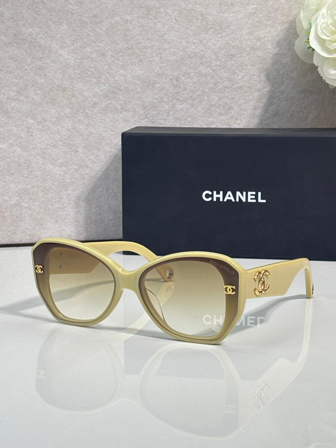 Light gold Chanel sunglasses with gold-tone logos on temples and tinted lenses