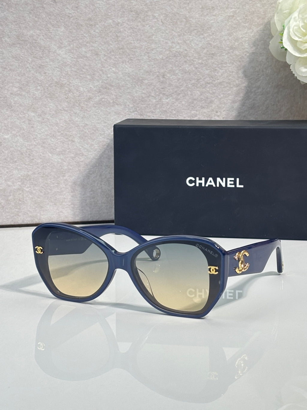 Blue Chanel sunglasses with gold emblem on temples and dark tinted lenses