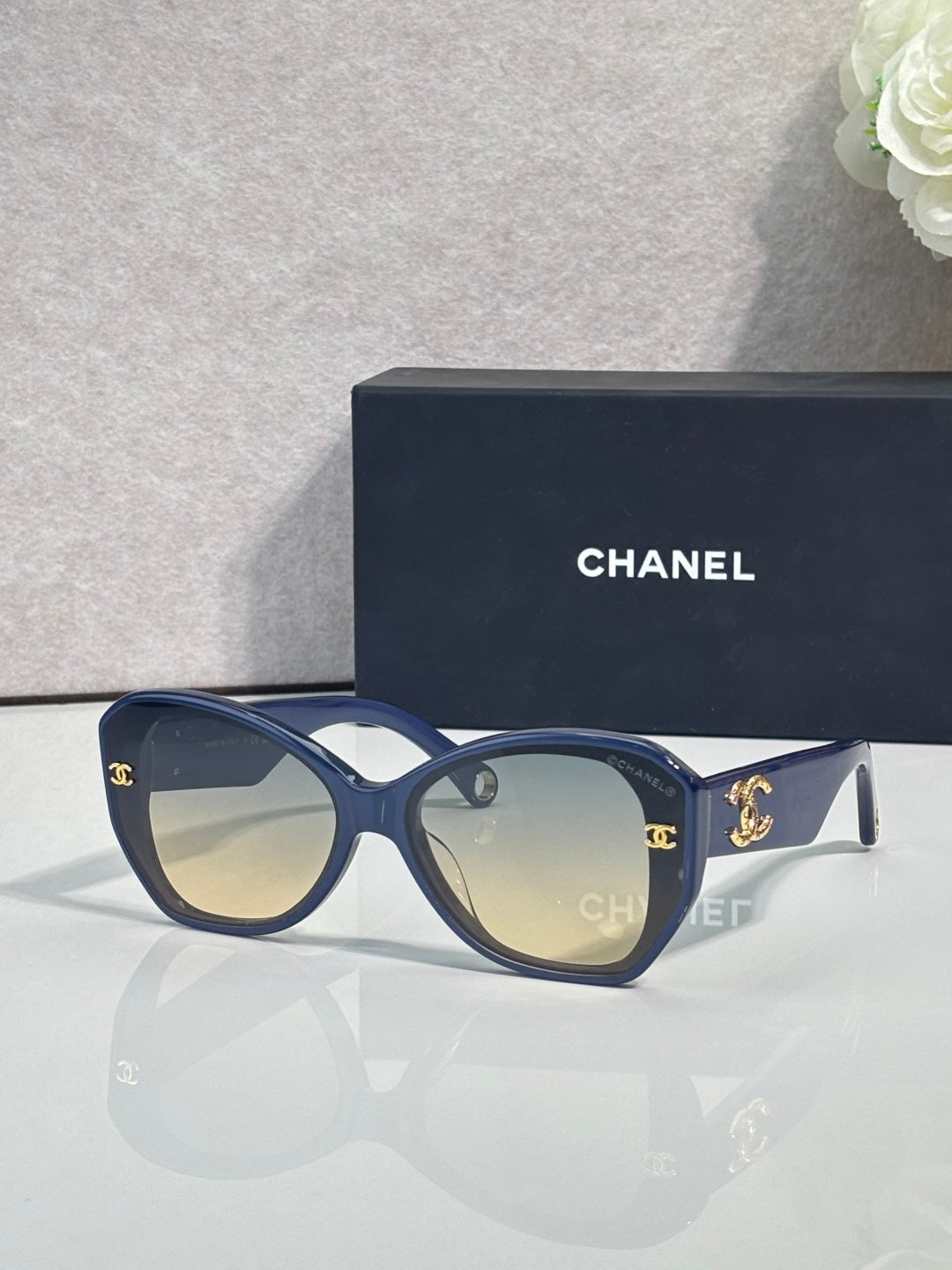 Blue Chanel sunglasses with gold emblem on temples and dark tinted lenses