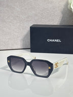 Dark blue square sunglasses with gold logo on temples and tinted lenses