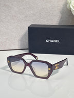 Deep purple square sunglasses with gold logo on temples and tinted lenses