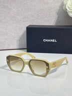 Light gold square sunglasses with gold logo on temples and tinted lenses