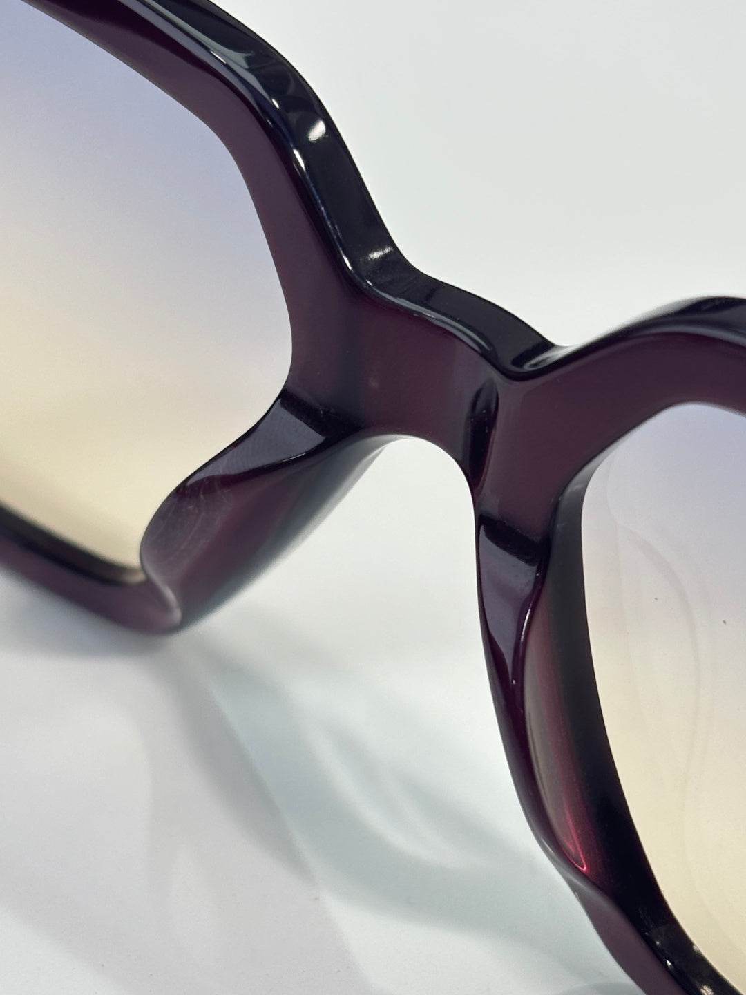 Purple glossy sunglasses frame close-up with curved front and temple