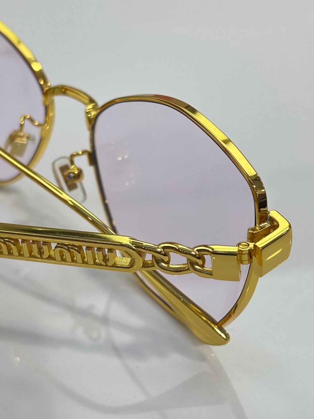 MiuMiu sunglasses, gold bridge and temple hinge close-up