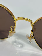 MiuMiu gold-tone sunglasses close-up with dangling crystal and charm details