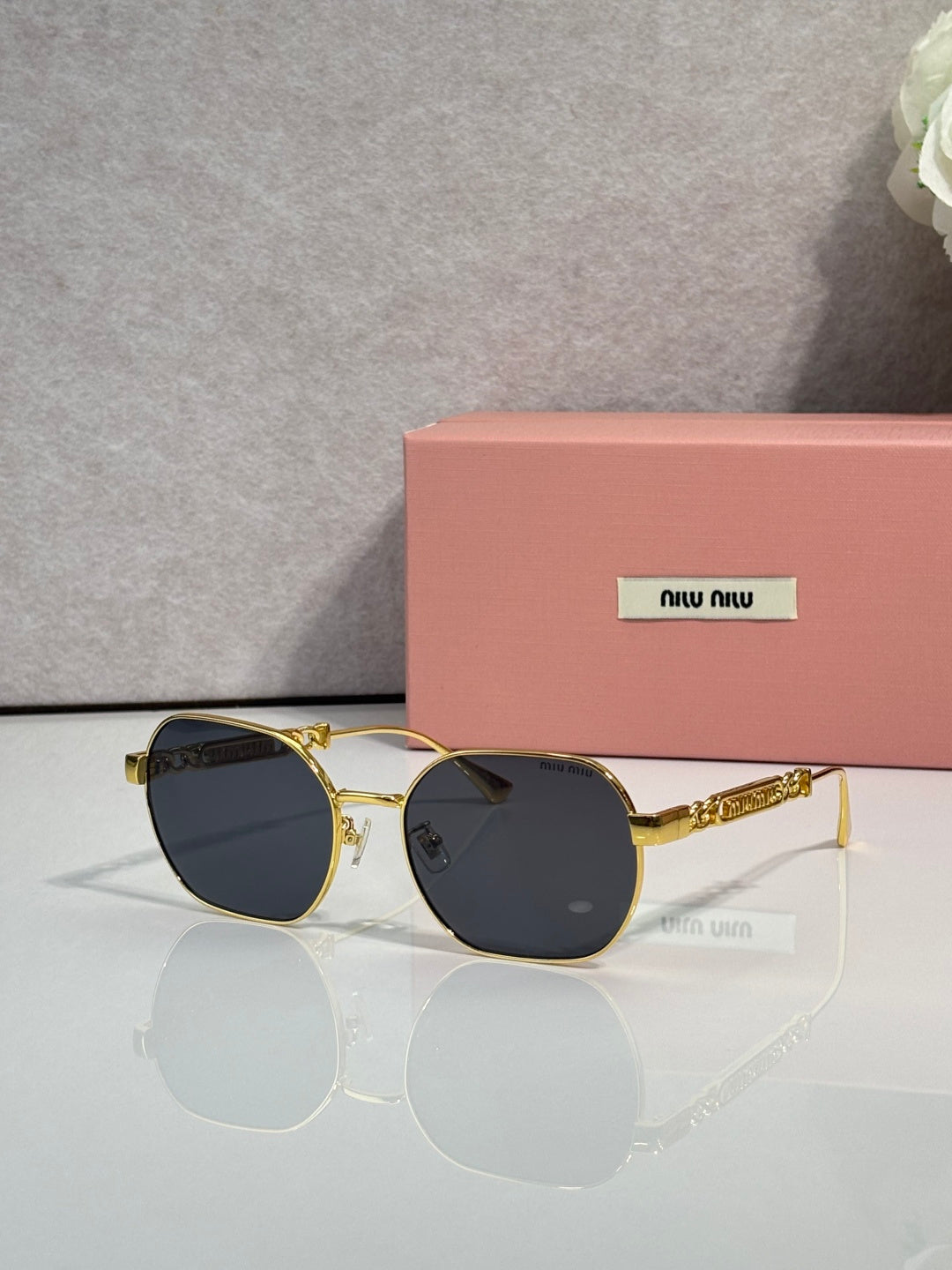 MiuMiu sunglasses with dark lenses and gold-tone rounded frames