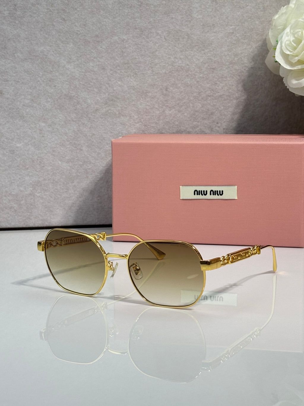 MiuMiu sunglasses with light brown lenses and gold-tone rounded frames