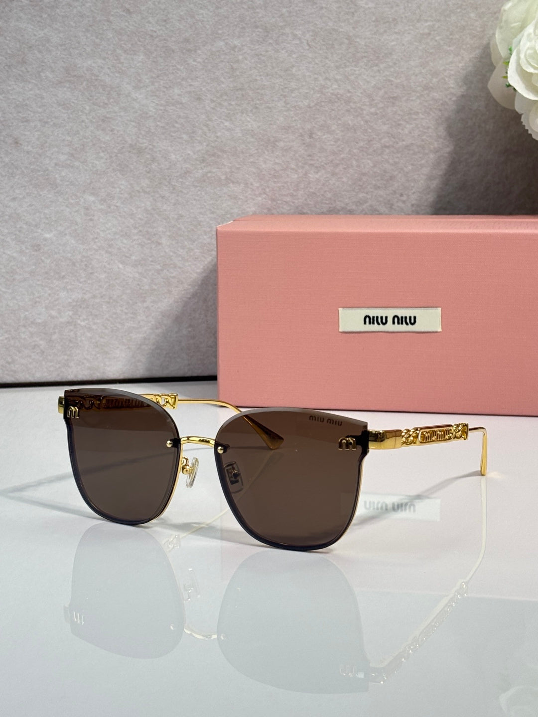 MiuMiu glasses with dark brown tinted lenses and gold metal frame