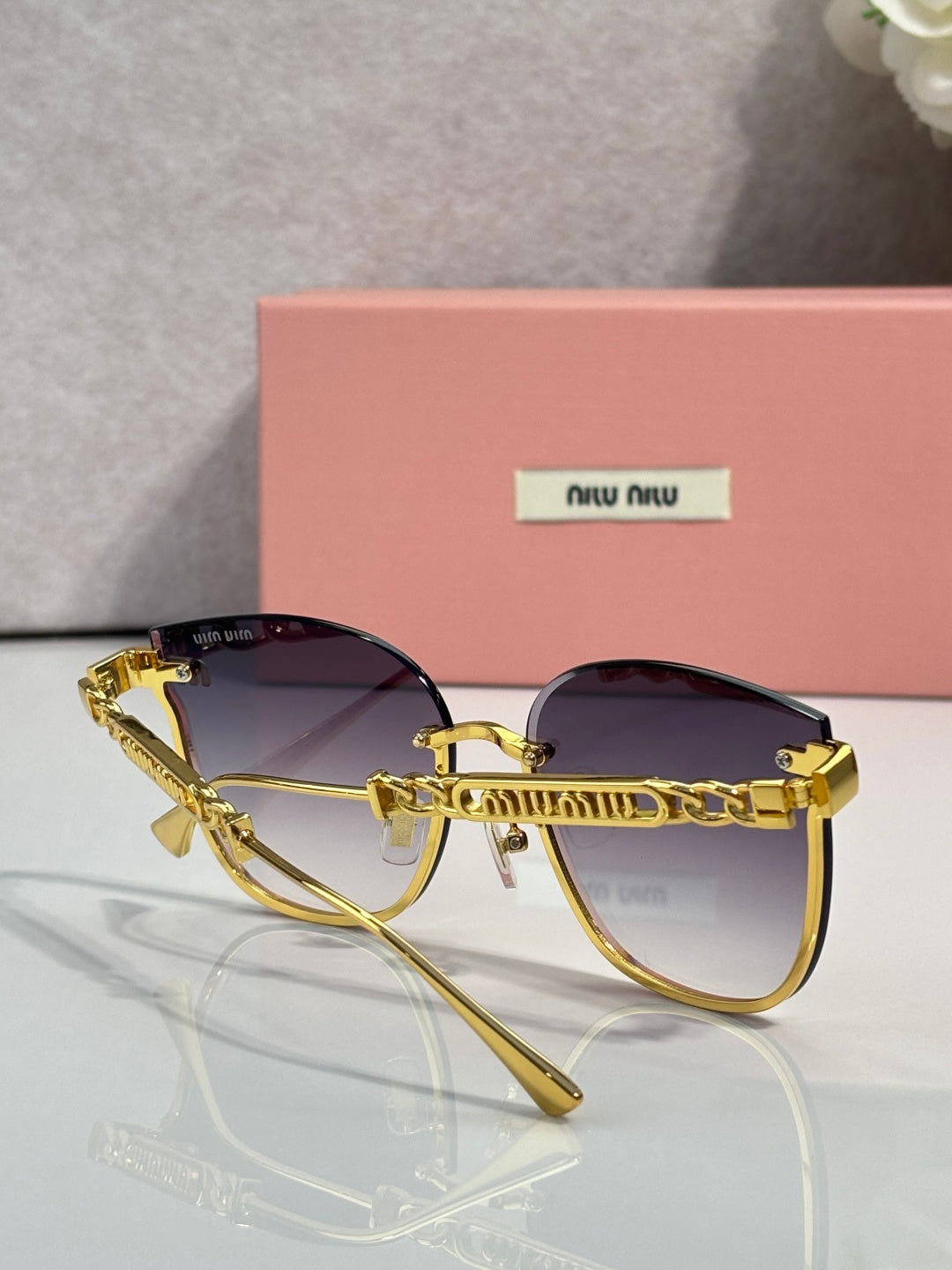 MiuMiu glasses with gold frame and deep purple tinted lenses