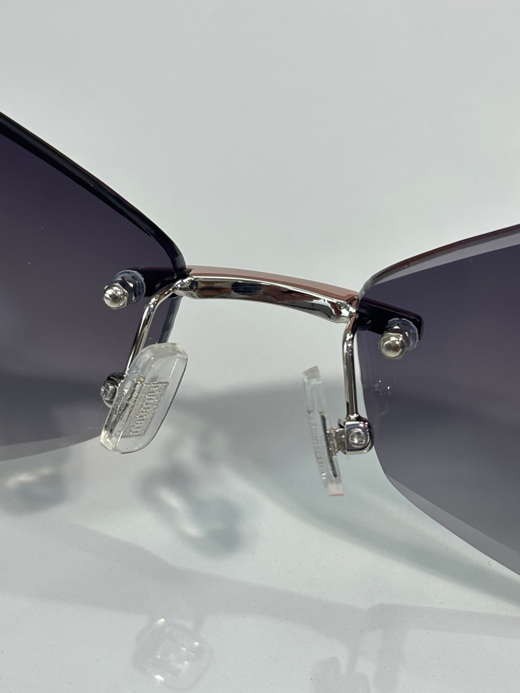 Sunglasses close-up: silver hinge and temples with dark lens sections