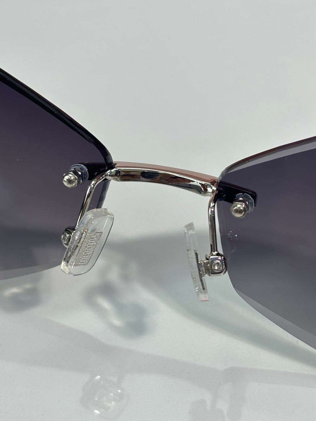 Sunglasses close-up: silver hinge and temples with dark lens sections