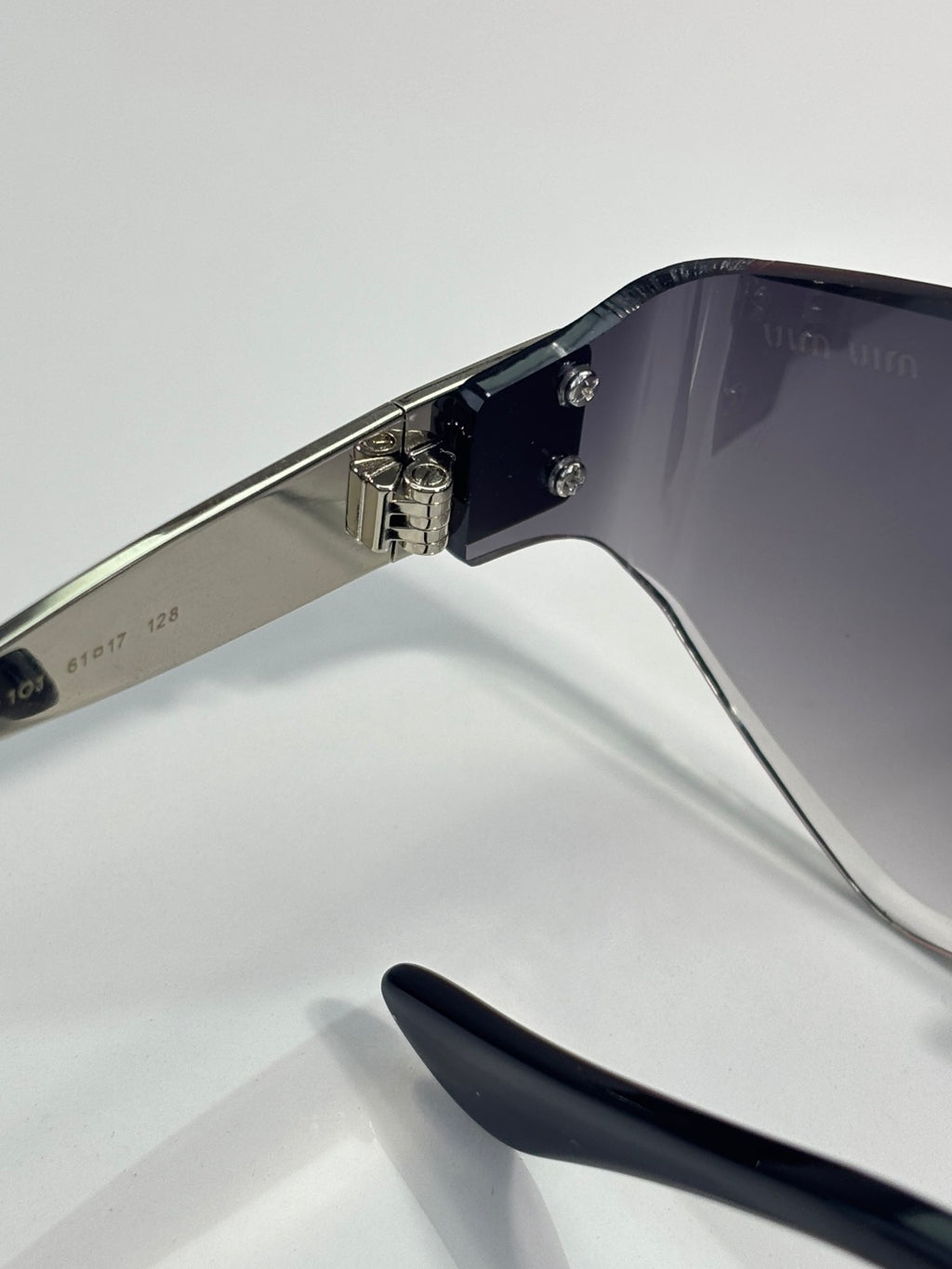 Sunglasses side view: silver temples with black tips and metal hinges