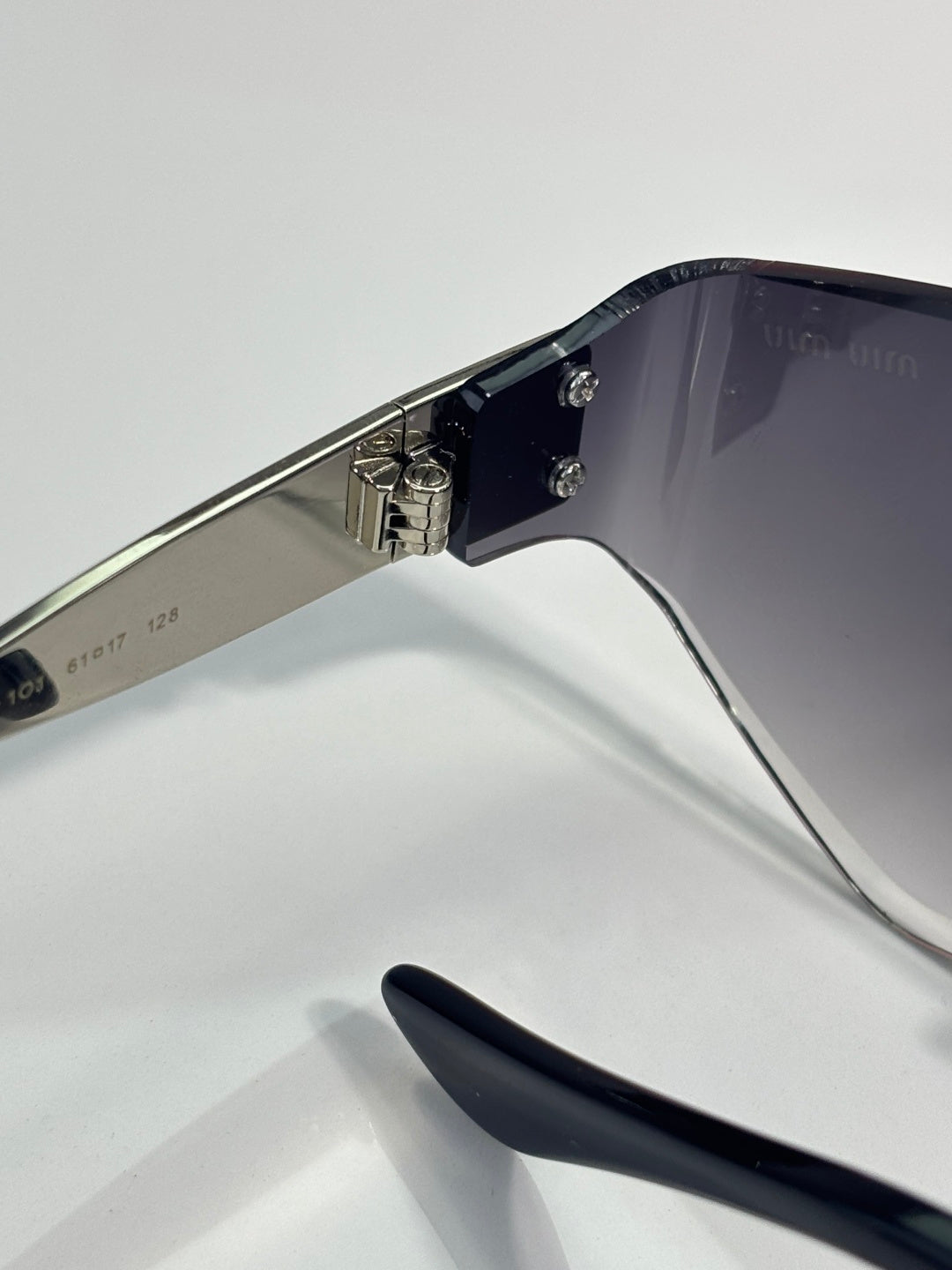 Sunglasses side view: silver temples with black tips and metal hinges