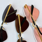 Close-up of gold-tone glasses frames with black temple tips and tinted lenses