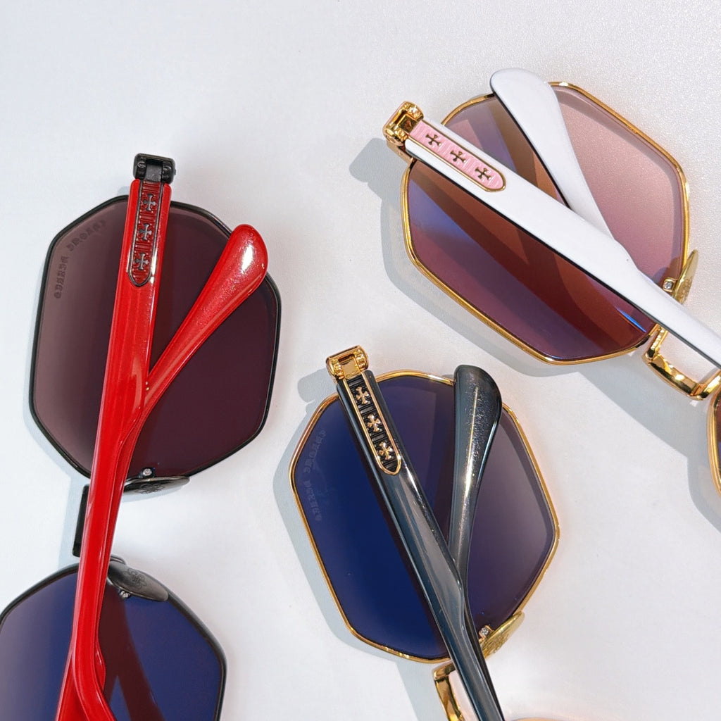 Octagonal sunglasses with gold frames and tinted lenses, shown with red and blue pairs