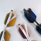 Assorted sunglasses with gold frames and tinted lenses, including brown and blue pairs