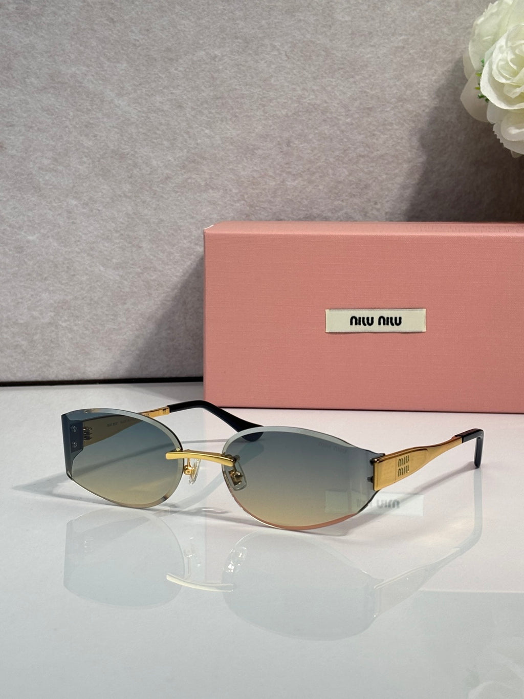 MiuMiu cat-eye sunglasses with olive lenses, black-maroon frame, gold accents