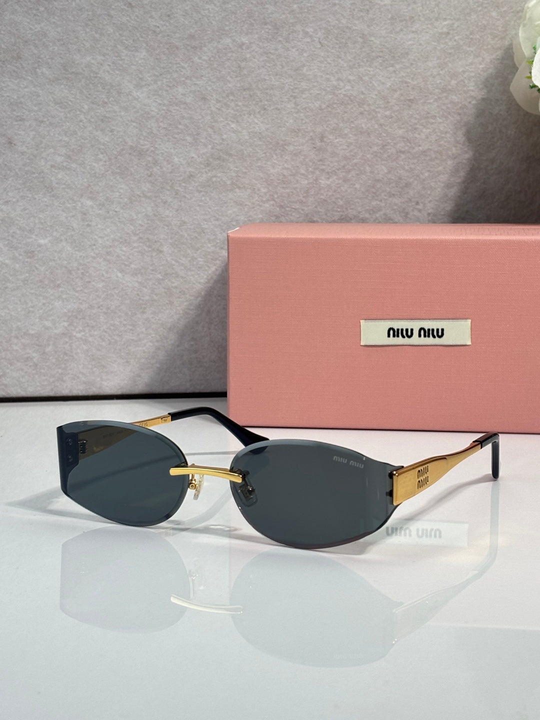 MiuMiu cat-eye sunglasses with deep green lenses, maroon frame, gold accents