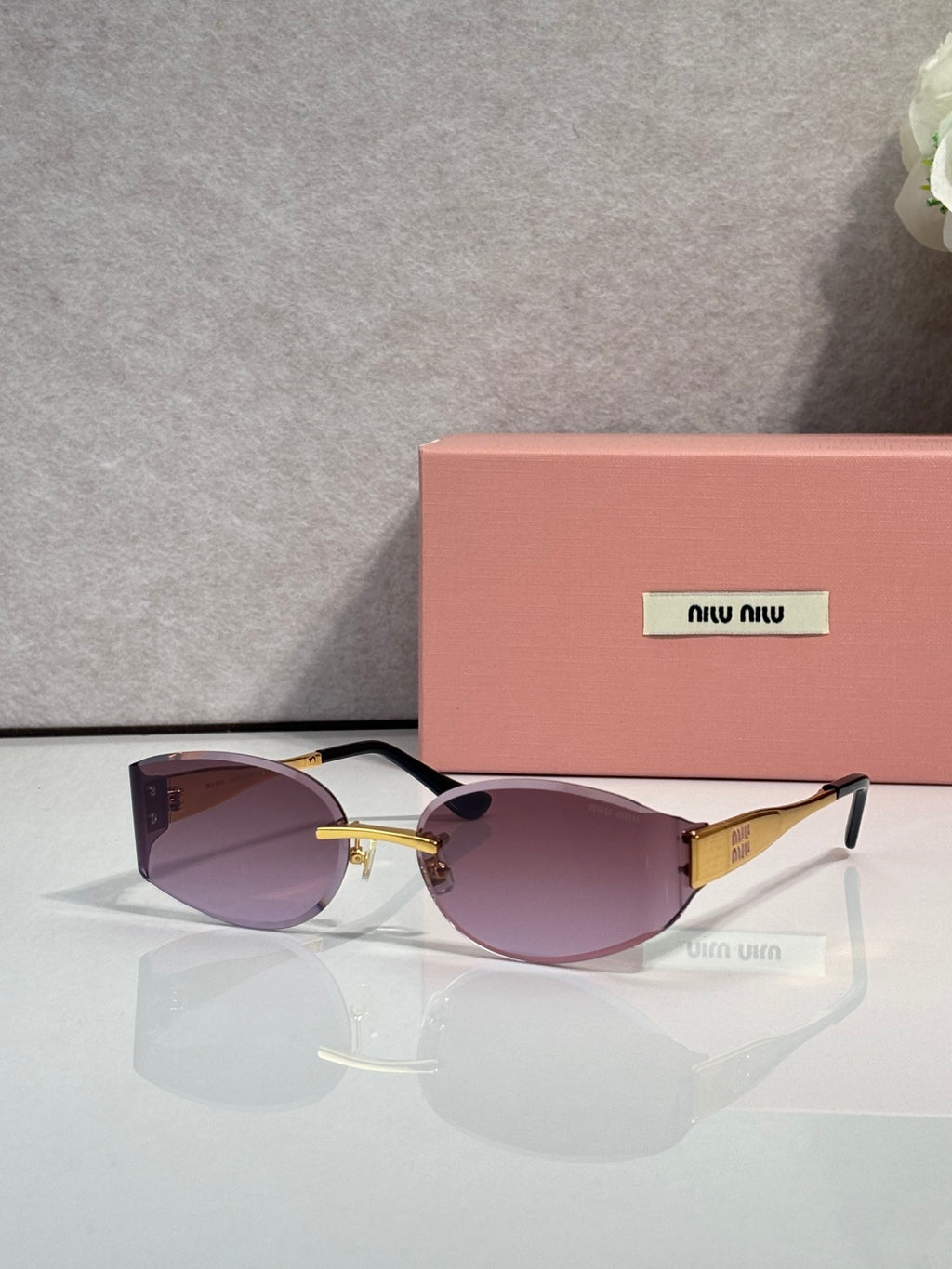 MiuMiu cat-eye sunglasses with purple lenses, maroon acetate frame, gold accents