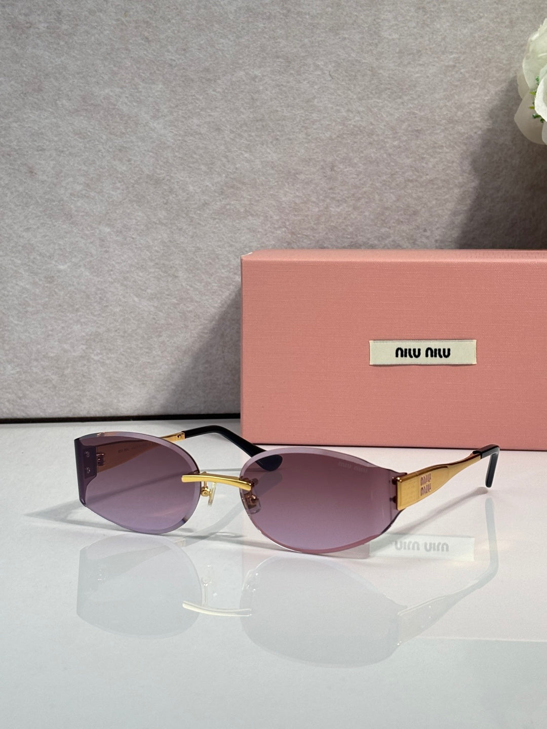 MiuMiu cat-eye sunglasses with purple lenses, maroon acetate frame, gold accents