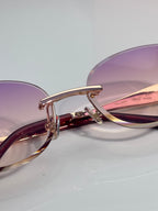 MiuMiu sunglasses close-up: purple lenses and maroon frame, gold metal hinge