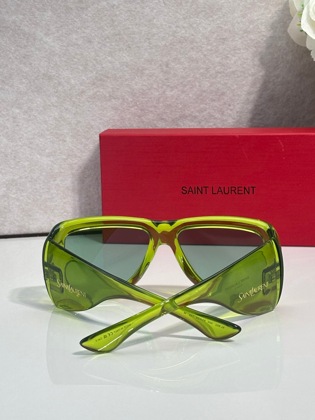 Neon green sunglasses with tinted lenses and crossed bow bridge detail