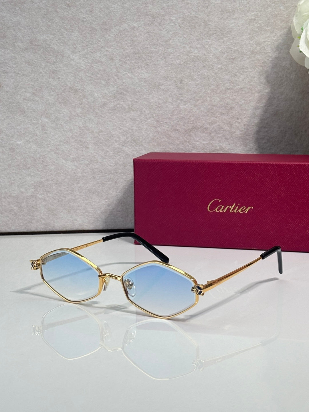 Cartier glasses, gold-tone frames with light blue lenses and black temple arms