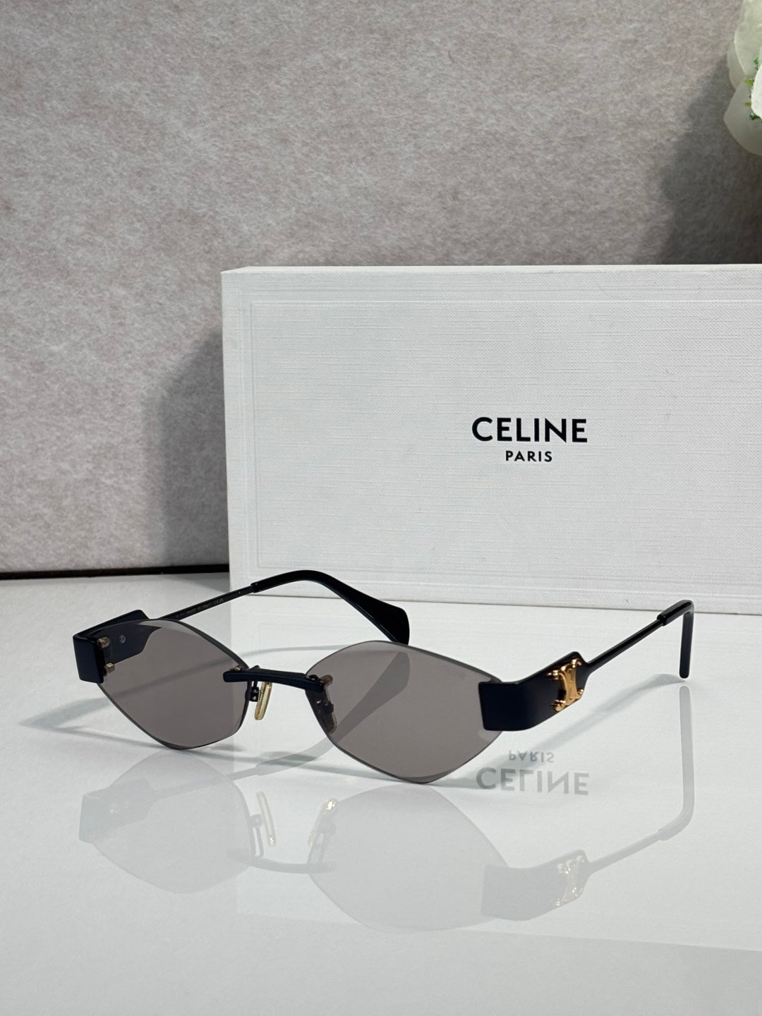 Celine sunglasses with dark lenses, black frame, and gold-tone temples.