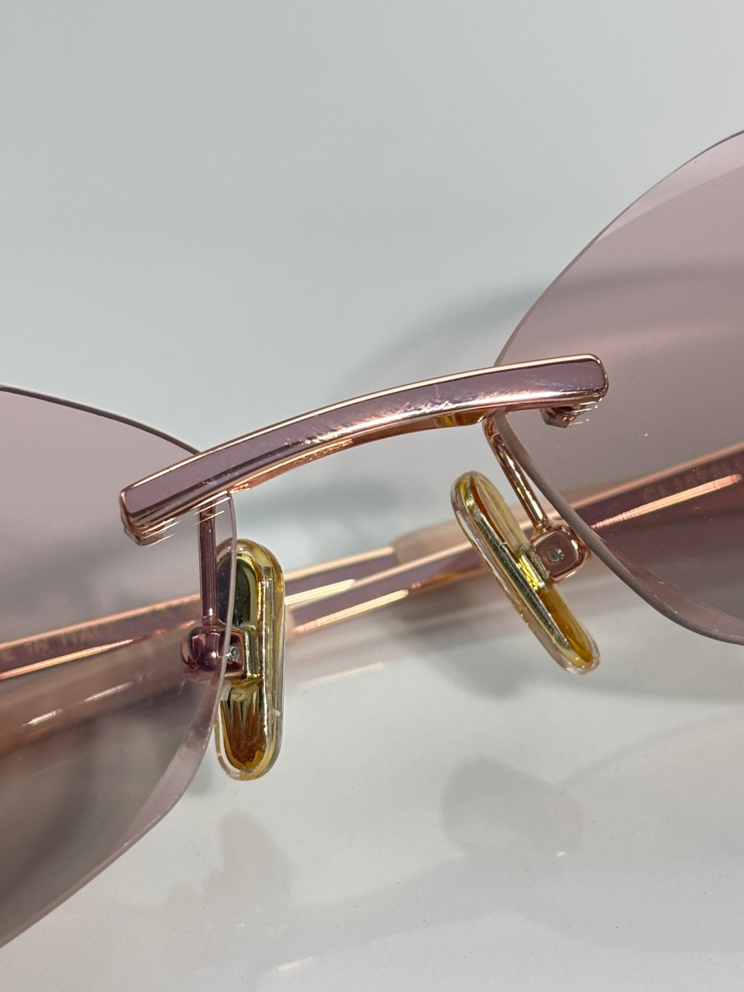 Celine sunglasses closeup: rose-gold front bar and gold-tone temple hinge.
