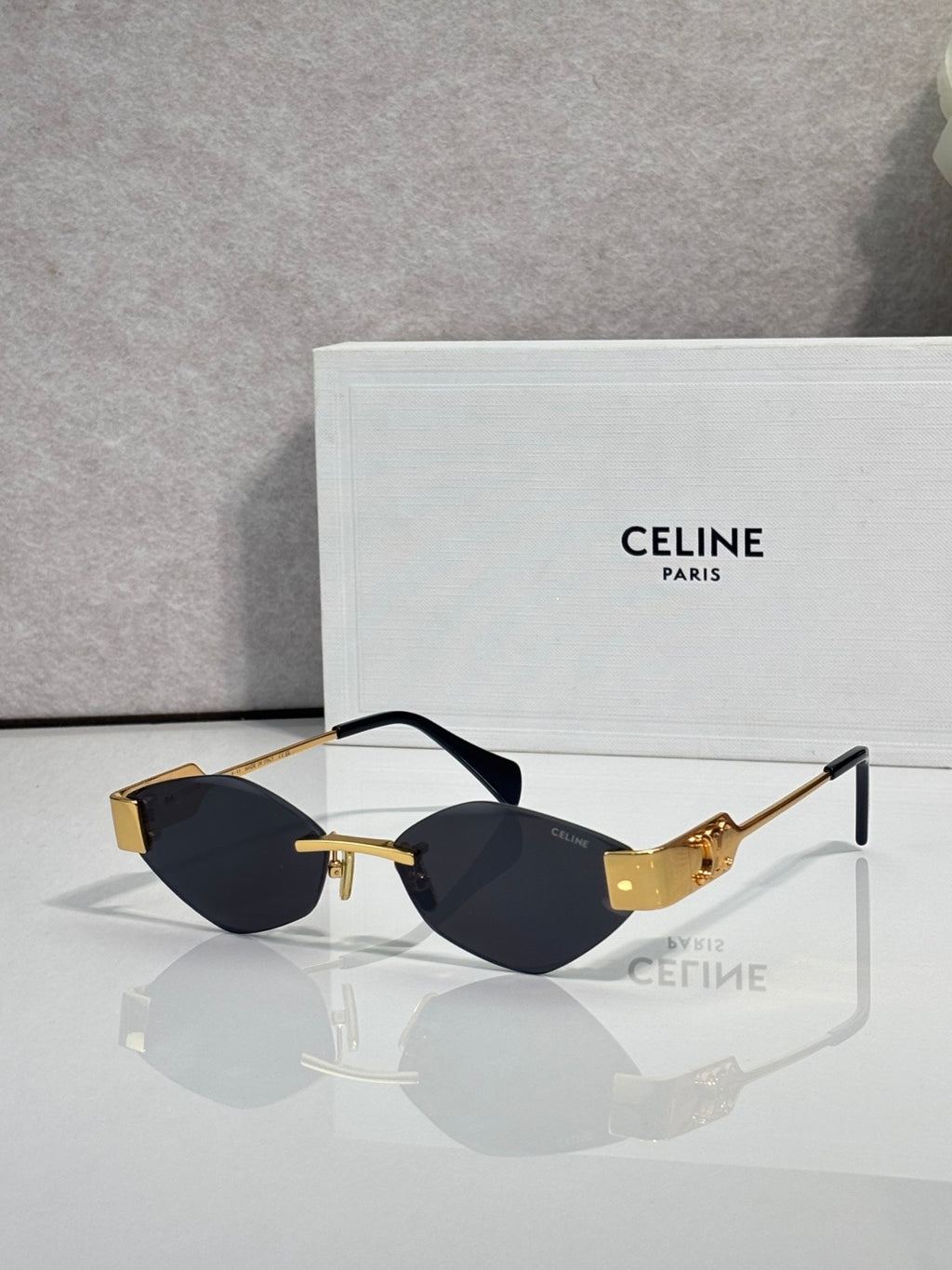 Celine sunglasses with dark lenses, black frame, and gold-tone detailing.