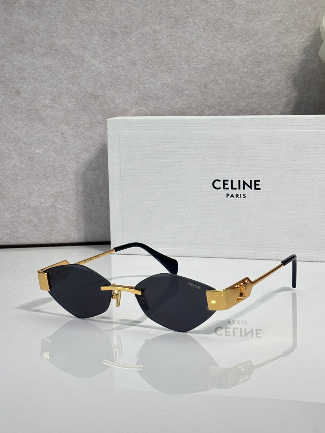Celine sunglasses with dark lenses, black frame, and gold-tone detailing.