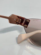 Celine sunglasses closeup: rose-gold frame hinge and transparent bridge bar.