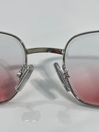 Silver-tone glasses with pink-tinted lenses and engraved hinge arms