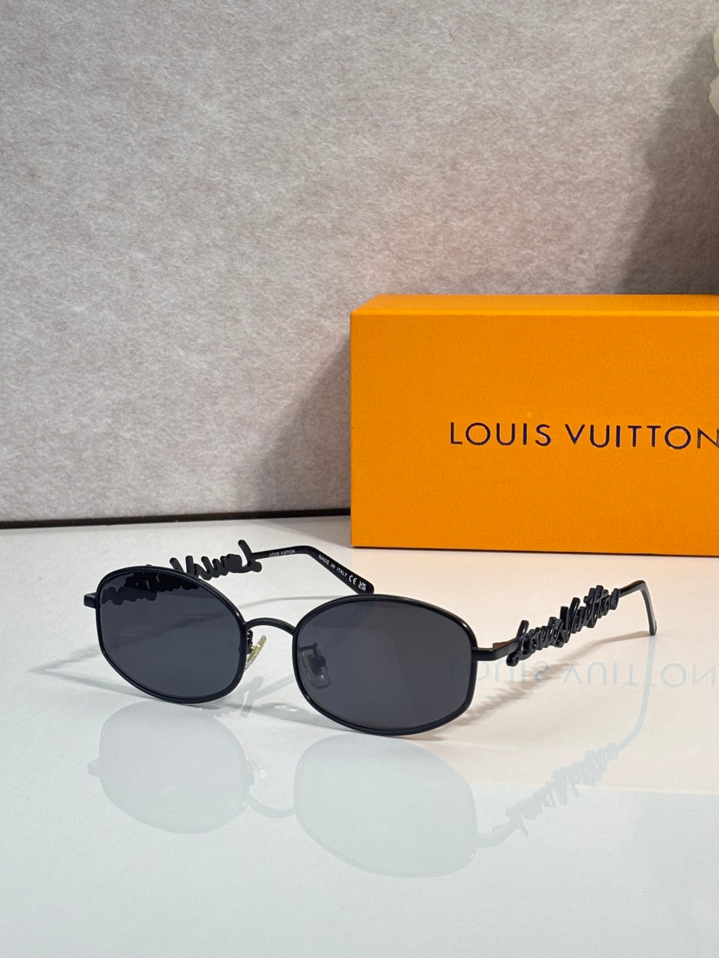 Louis Vuitton sunglasses with dark frames and dark lenses, rounded shape and logo temple