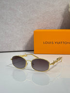 Louis Vuitton sunglasses with gold frames and dark brown lenses, ornate side embellishment