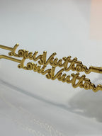 Close-up of Louis Vuitton glasses arm with gold cursive logo detailing