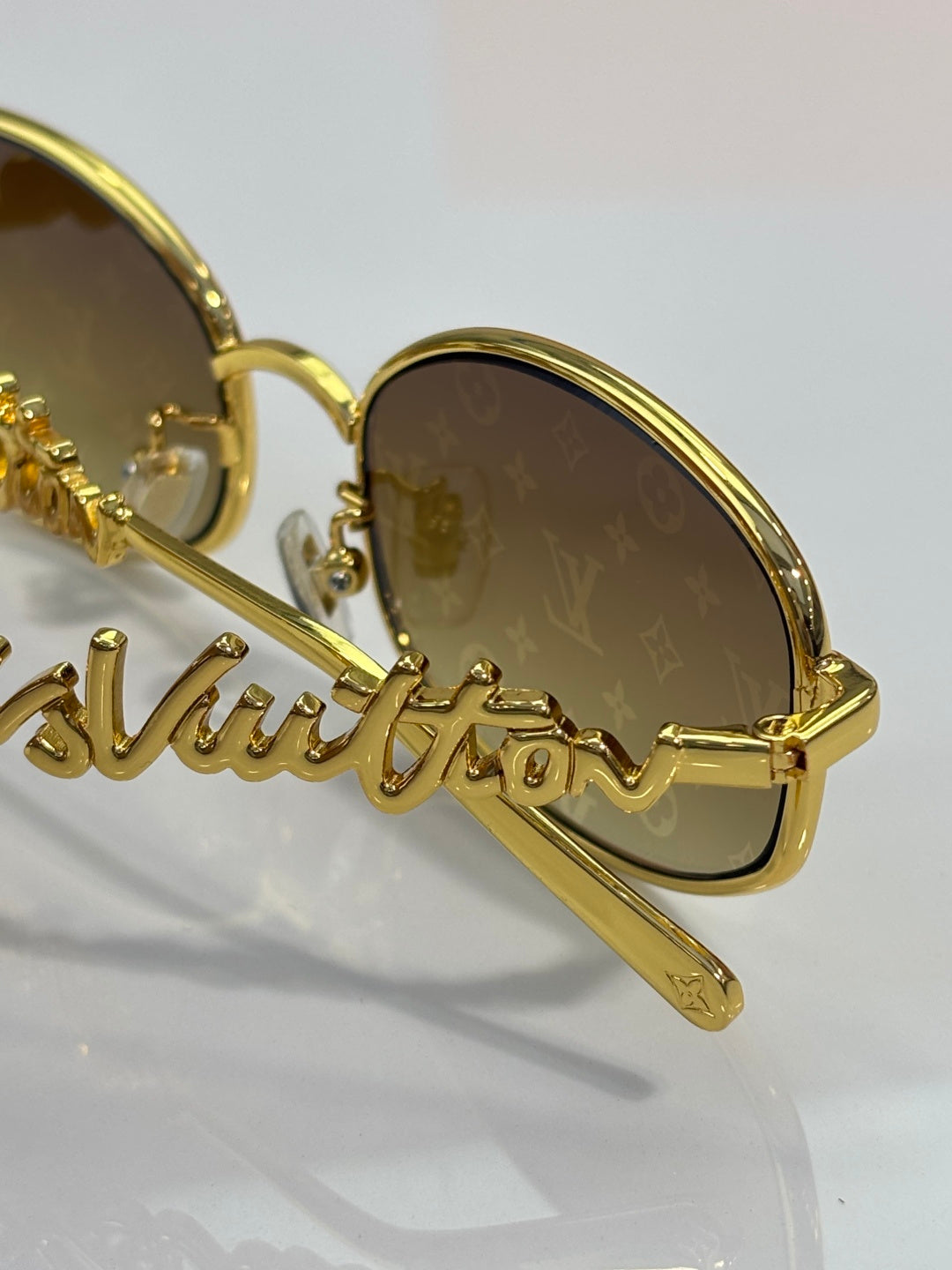Close-up of Louis Vuitton round glasses with gold frame and amber tinted lenses
