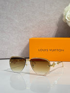 Louis Vuitton oval sunglasses with gold-tone frame and amber-tinted lenses