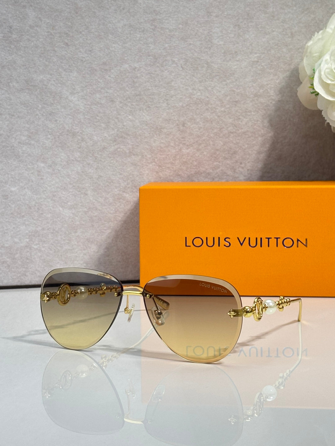 Louis Vuitton oval sunglasses with gold-tone frame and amber lens tint