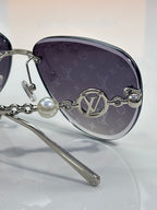 Louis Vuitton oval sunglasses close-up with dark lenses and chain-link arm detail
