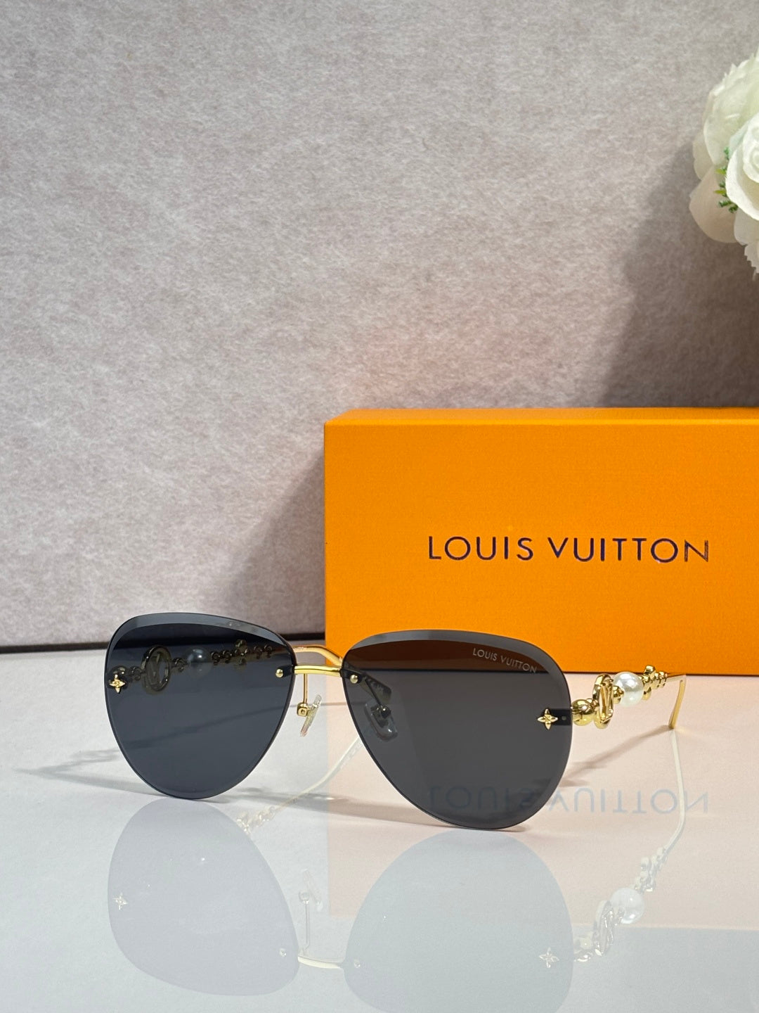 Louis Vuitton oval sunglasses with dark lenses, gold-tone details, and metal frame