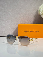 Louis Vuitton oval sunglasses with dark gradient lenses and gold-tone metal frame