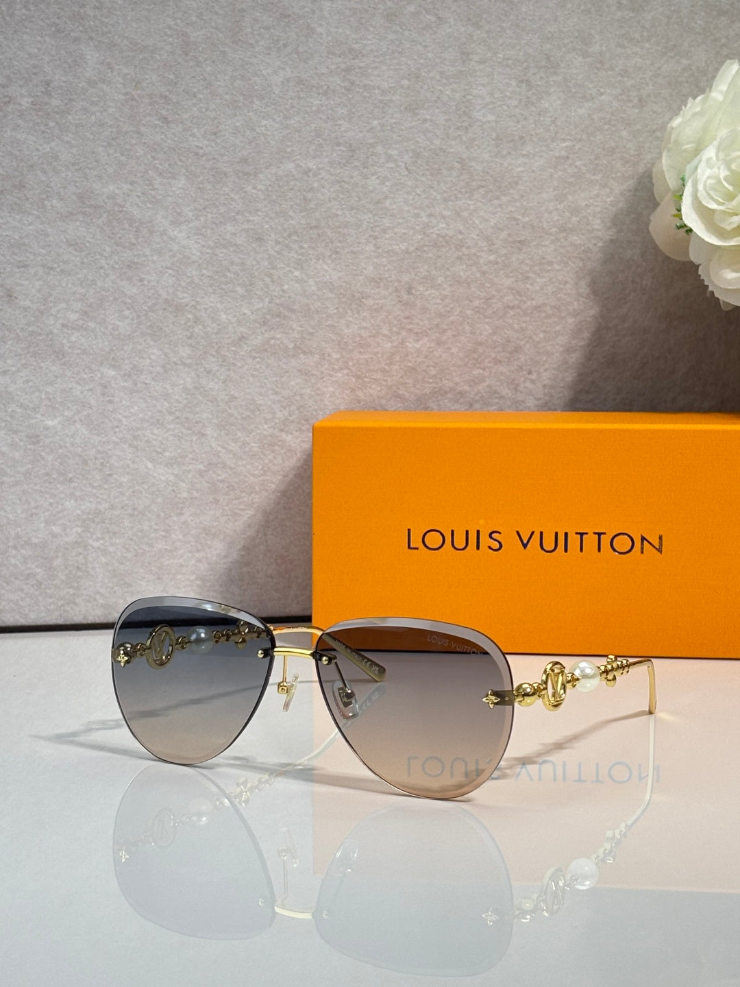 Louis Vuitton oval sunglasses with dark gradient lenses and gold-tone metal frame