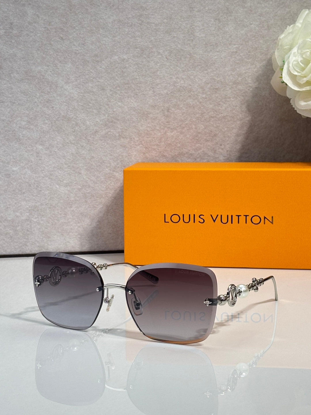 Sunglasses with dark purple-gray lenses and gold-tone metal temples