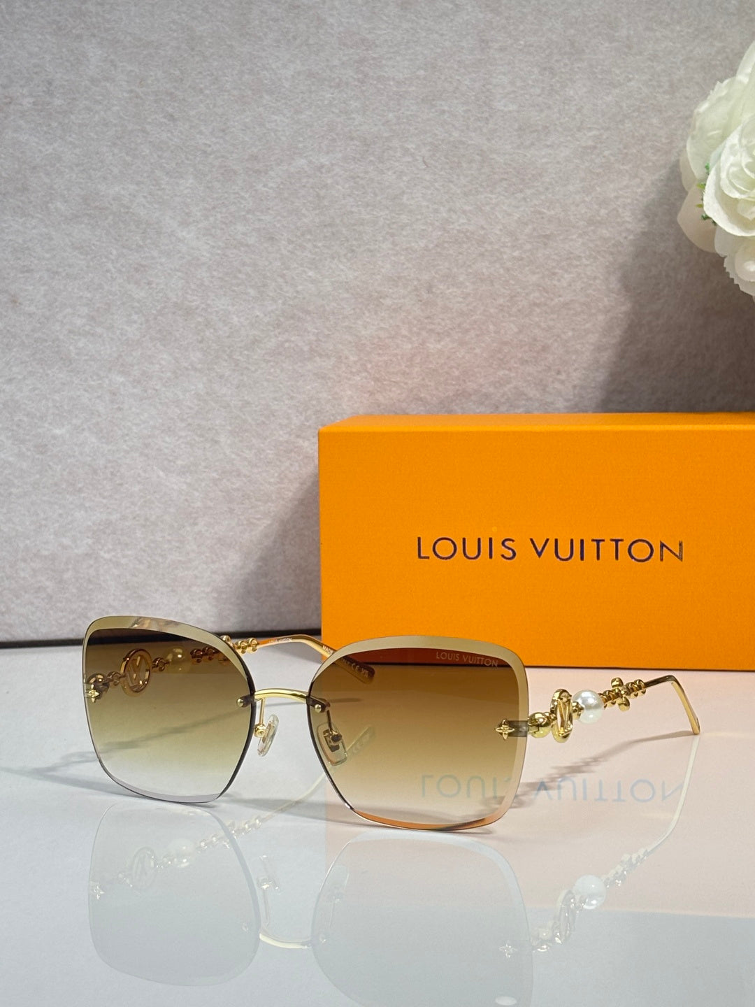Sunglasses with tan gradient lenses and gold-tone metal frame and temples