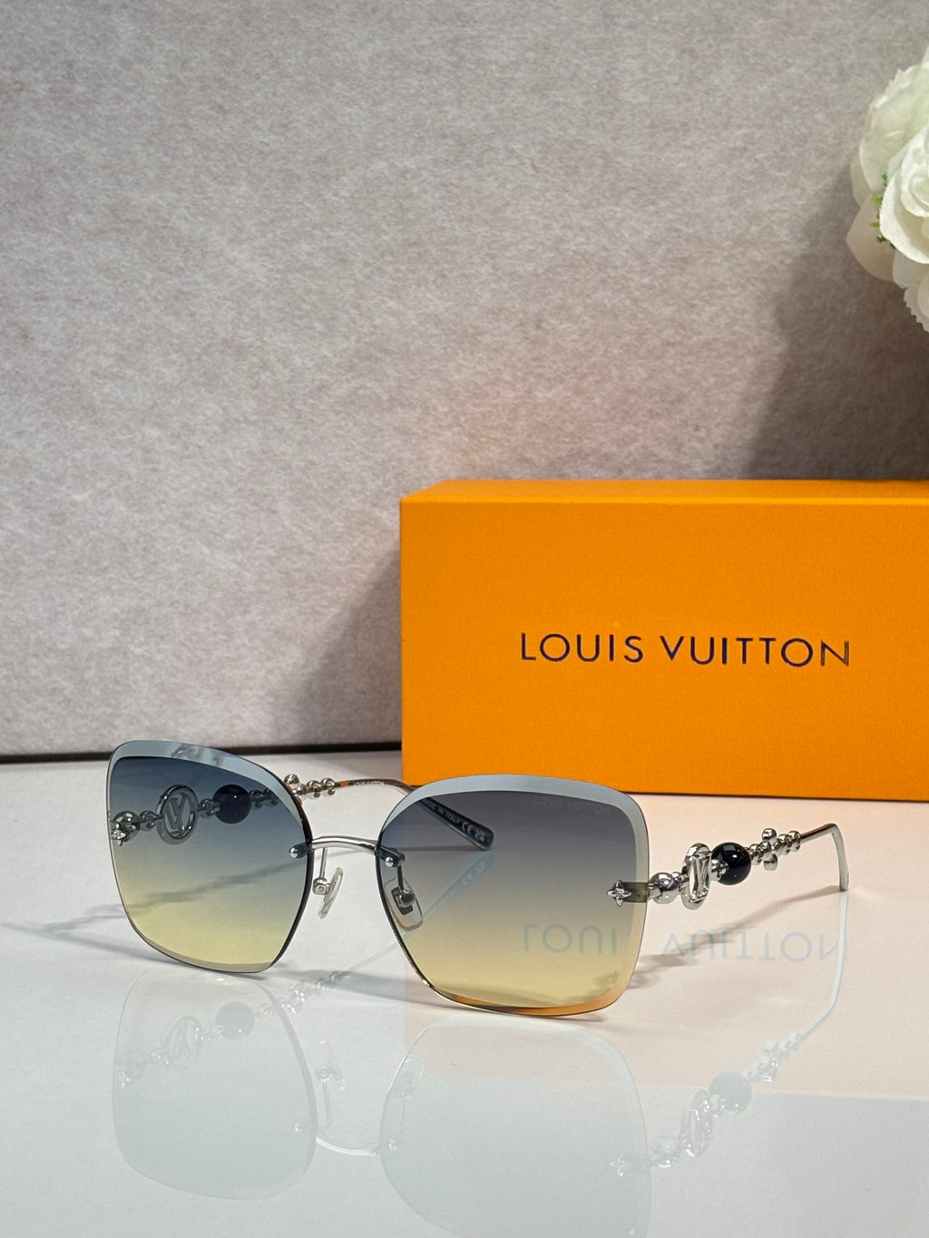 Sunglasses with blue-gray gradient lenses and gold-tone metal frame details