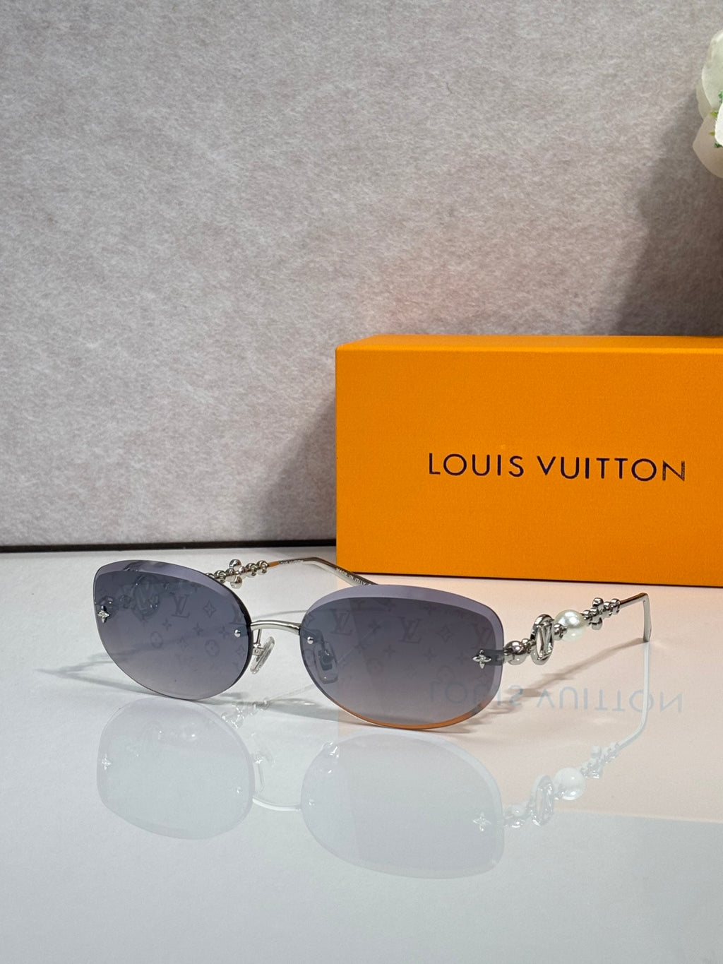 Louis Vuitton sunglasses with dark gray-purple lenses and gold metal frame